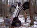 1989 Ford F-350 - An off-road vehicle is stuck between two trees in a snowy wooded area, with onlookers observing the situation.