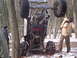 1989 Ford F-350 - An off-road buggy is seen upside down in a snowy forest with onlookers.