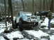 1989 Ford F-350 - This modified SUV navigates a challenging snowy trail with other vehicles in the background.