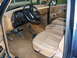 1988 Ford Bronco - The interior of a 1987 Ford Bronco shows tan cloth seats and a dashboard with wood grain trim.