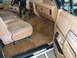 1988 Ford Bronco - Interior view of a vehicle tan upholstery, a dashboard, and door panel details.