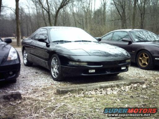Black 1995 Ford Probe with chrome wheels, parked outdoors