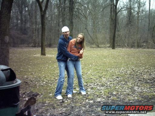 Couple embracing in a park with a trash can in the foreground
