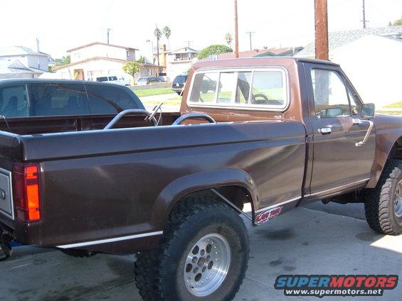 Brown pickup truck, lifted, with chrome trim and racing wheels, viewed from the side