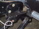 1990 Ford Bronco - Close-up view of vehicle frame and suspension components, with visible bolts and a braided hose.