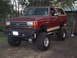 1990 Ford Bronco - This modified Ford Bronco features a significant lift kit and oversized tires, giving it an aggressive stance.