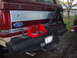 1990 Ford Bronco - Rear view of a red Ford Bronco showing its bumper, spare tire carrier, and a toolbox attached.