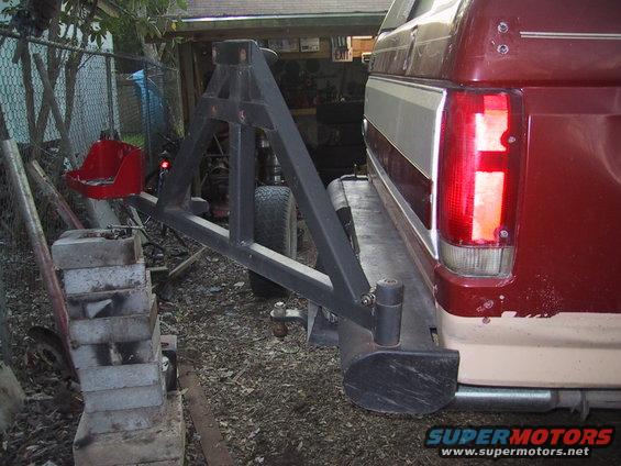 Red and tan SUV rear view with spare tire carrier and aftermarket bumper