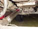 1989 Ford Bronco - Underside view of a vehicle's driveshaft and transmission, showing mechanical components and a tire.