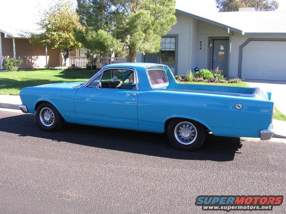 Blue 1966 Ford Ranchero parked on a street in front of a house, side view