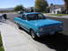 1966 Ford Ranchero - A bright blue 1966 Ford Ranchero is parked on a suburban street, showing its distinctive grille and front end.