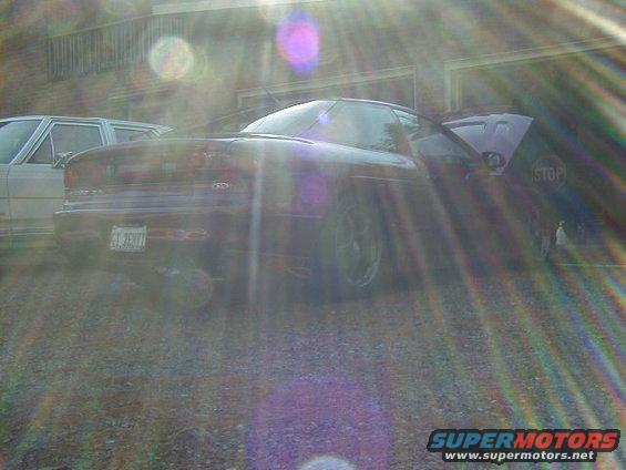 Dark 1994 Ford Probe with hood open, parked next to another car