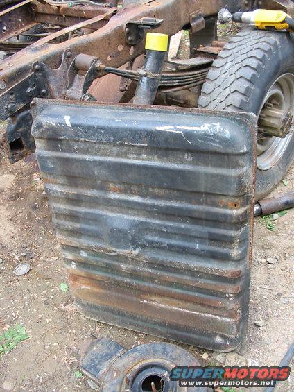 Black fuel tank with ribbed texture, part of a truck frame visible
