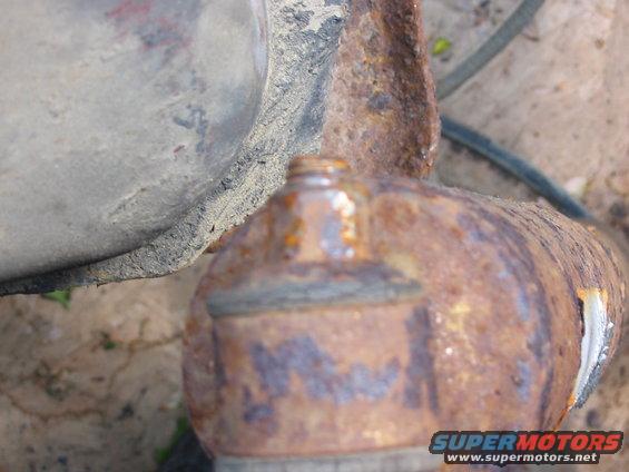 Close-up of a heavily rusted suspension component, possibly a ball joint or tie rod end
