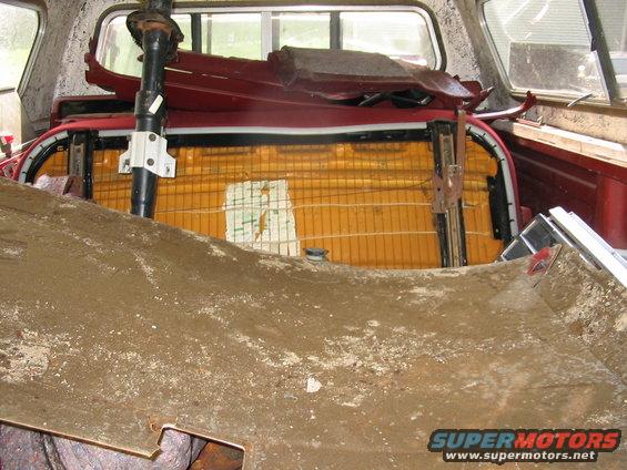 Pickup truck bed filled with parts, including seats and steering column