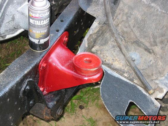 Spray can next to a red-painted suspension component on a truck frame