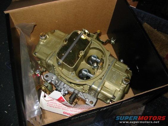 Gold carburetor in a cardboard box. Instructions are attached