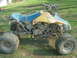 1992 Ford Crown Victoria - This ATV appears to be in rough condition, with a torn seat and significant mud coverage.