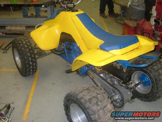 Yellow and blue ATV with knobby tires and a blue frame, seen from the right front