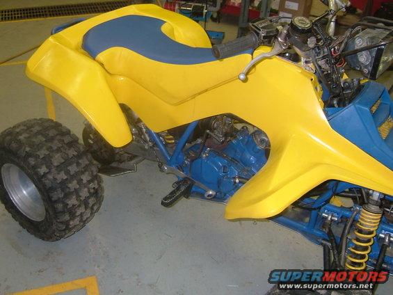 Yellow and blue ATV side view with knobby tires