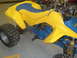 1992 Ford Crown Victoria - This yellow and blue ATV features a two-tone seat and knobby tires, seen from the side.