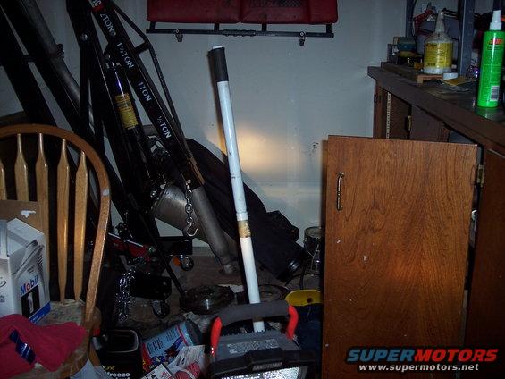 Workshop scene with engine hoist, wooden chair, and cabinets