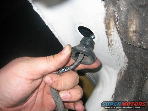 Pull this from the outside while stuffing it through the from the inside and it will pop out. Follow the wire to the clip and just un-hook the light. Now it is completely off. (do this for both sides)