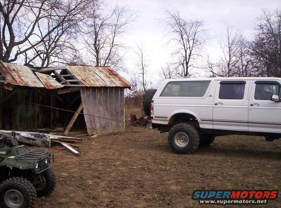 1992 Ford C-150 (Centurion Conversions) parked on muddy ground next to an old shed