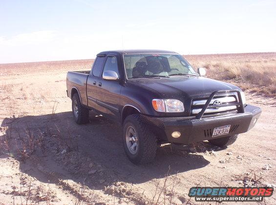 Black 2003 Toyota Tundra pickup truck parked on dirt road with aftermarket bumper and brush guard