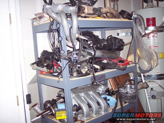Engine manifold and exhaust parts on a metal shelf unit
