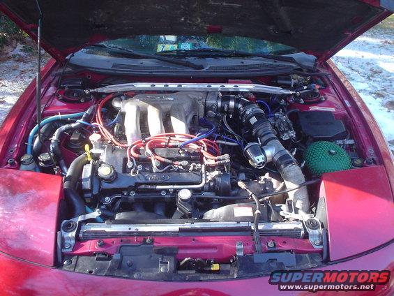 Red Ford Probe engine bay with aftermarket turbocharger and green air filter