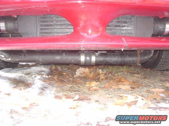 red car front bumper with intercooler and black exhaust pipes underneath