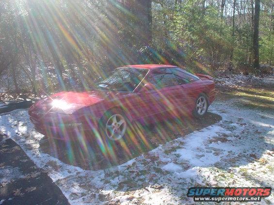 Red 1995 Ford Probe coupe in snow, 3q-front view