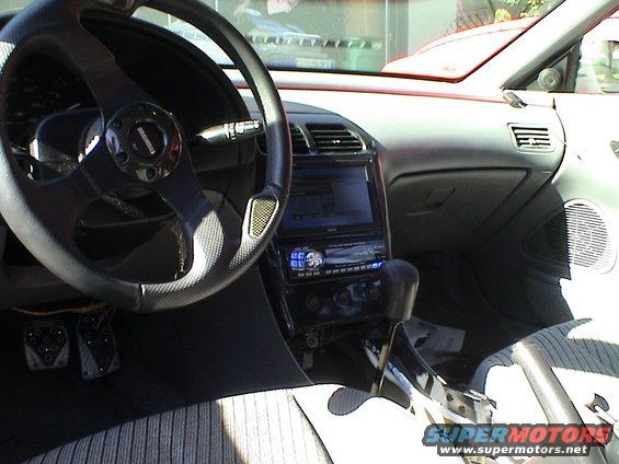 car interior with aftermarket steering wheel, stereo, and shifter