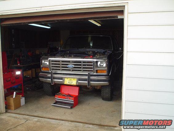 1984 Ford Bronco front view in garage with hood open and toolbox below