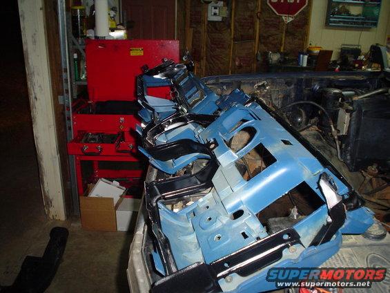 Disassembled blue dashboard and chrome trim pieces piled inside a vehicle
