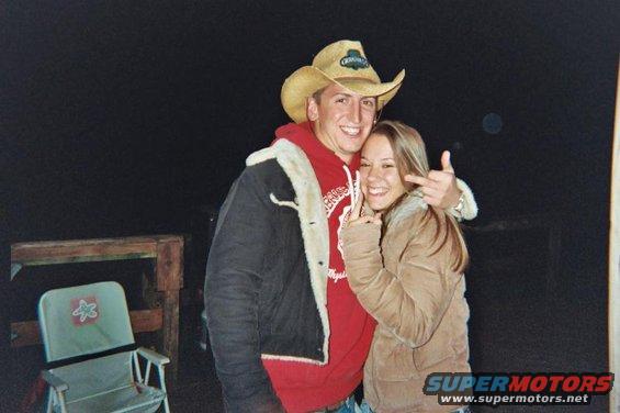 Couple posing for photo, man wearing cowboy hat and woman giving peace sign