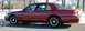 1999 Ford Crown Victoria - Side view of a red sedan with black wheels parked outdoors in winter.