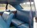 1993 Ford Bronco - The interior of a vintage vehicle features blue vinyl seats and seatbelts, with a view of the outdoors through the rear window.