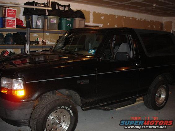 Black Ford Bronco side view with running boards and aftermarket wheels