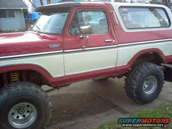 Red and white Ford Bronco, side view. Badge reads 'BRONCO'