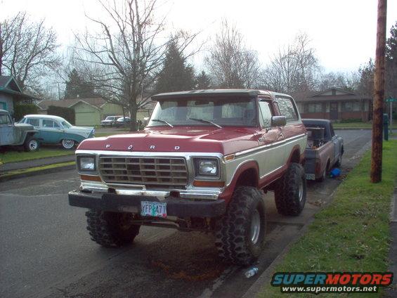 Red and cream Ford Bronco lifted with large tires, parked on a street. License plate YFP 471