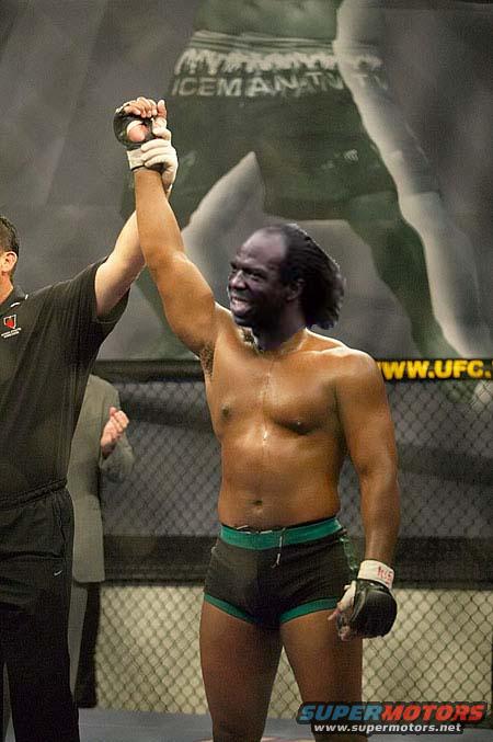 Fighter with arms raised in victory, UFC logo in background