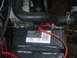 1986 Ford Mustang - Close-up view of a car battery and engine components.