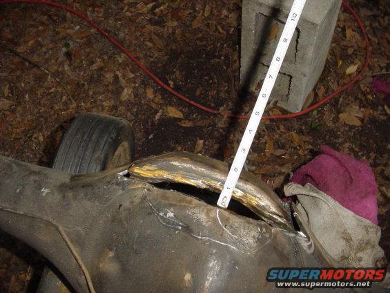 Close-up of a cut-open rear axle housing with a measuring tape indicating a gap