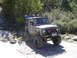 1996 Jeep Cherokee - Modified Suzuki Samurai parked on a dirt path with trees and rocks in the background.
