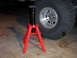 2000 Ford F-450 - A red jack stand is positioned next to a large tire, suggesting vehicle maintenance or repair.