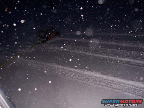 Person being pulled by a rope in a snowy landscape at night