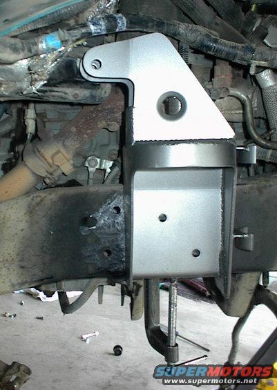 Custom metal bracket clamped to a vehicle frame near engine components
