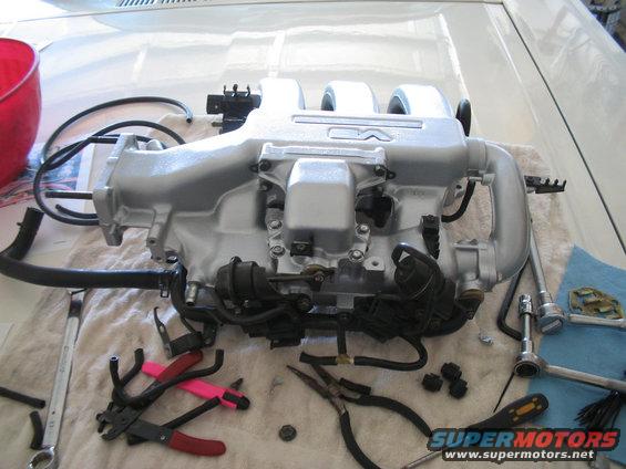 Silver engine intake manifold with hoses and tools